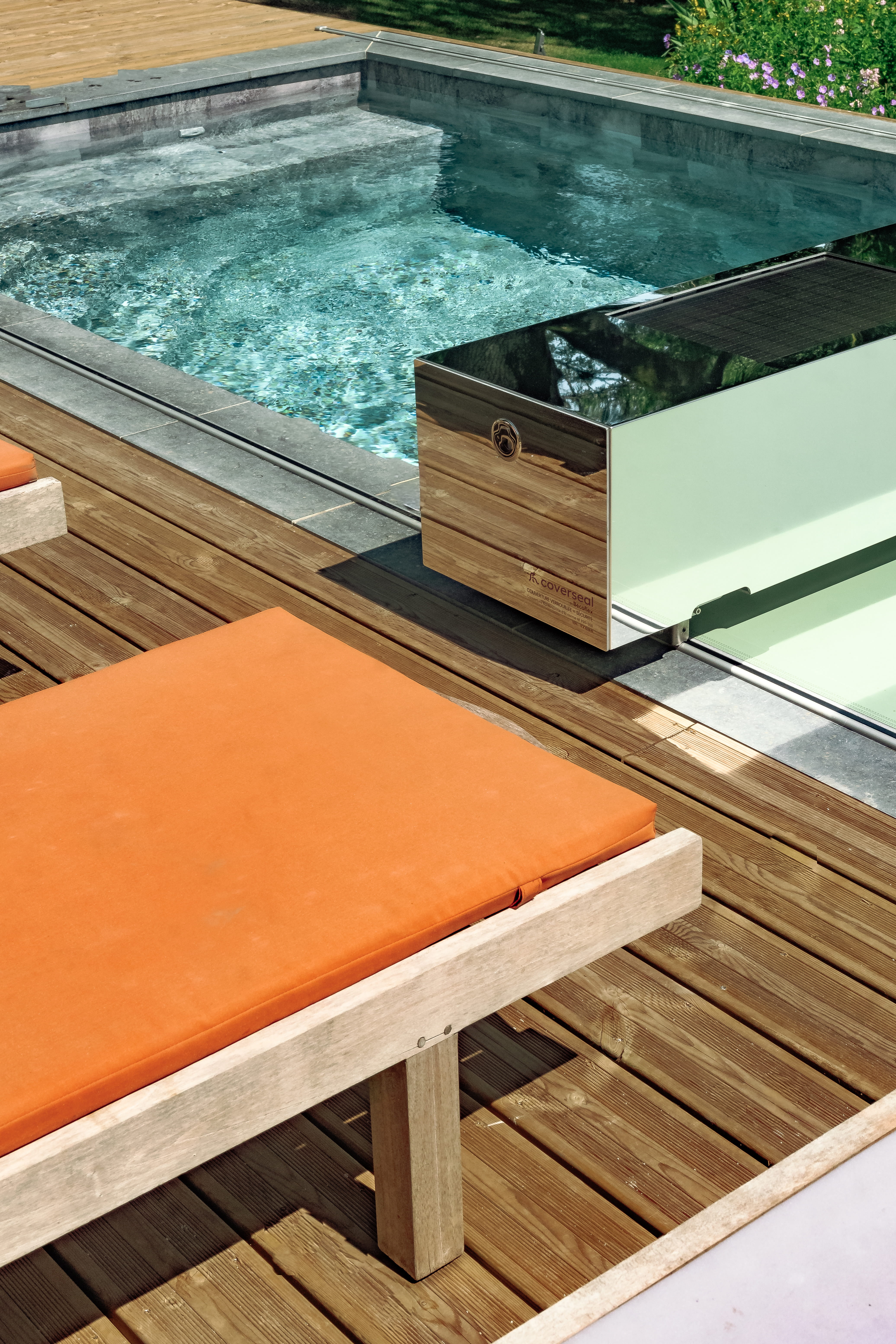 Habillage effet miroir, installé au bord d’une piscine sur une terrasse en bois.