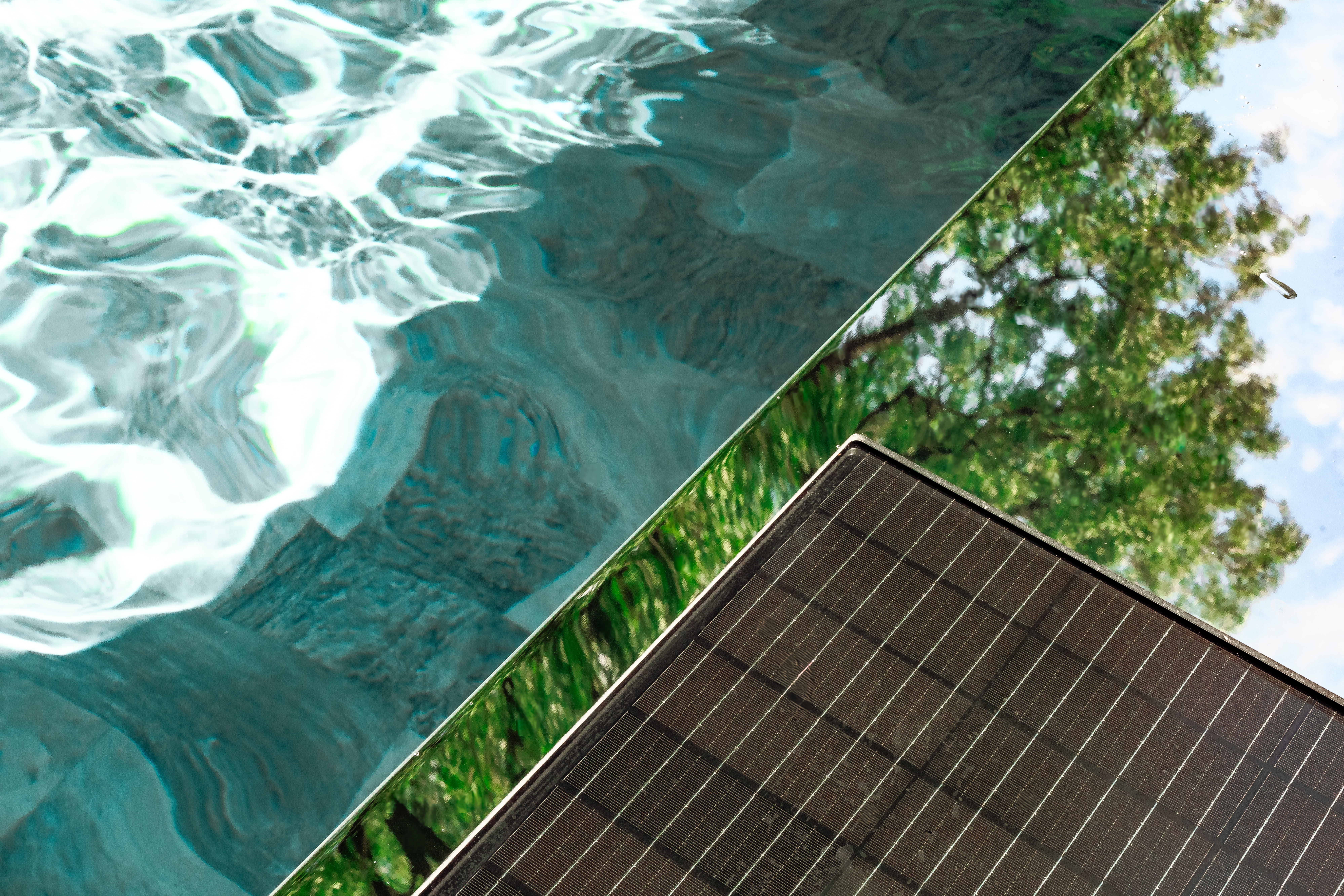 Vue rapprochée de l'habillage Coverseal, mettant en évidence son effet miroir et son intégration au bord de la piscine.